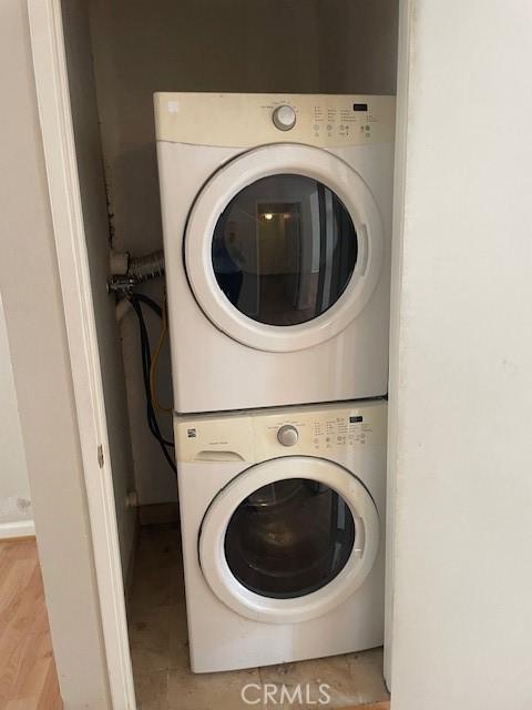 laundry area featuring baseboards, laundry area, and stacked washer and dryer
