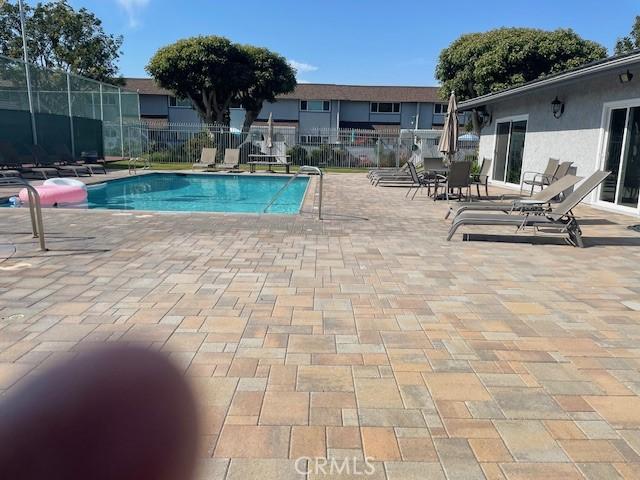 community pool featuring fence and a patio