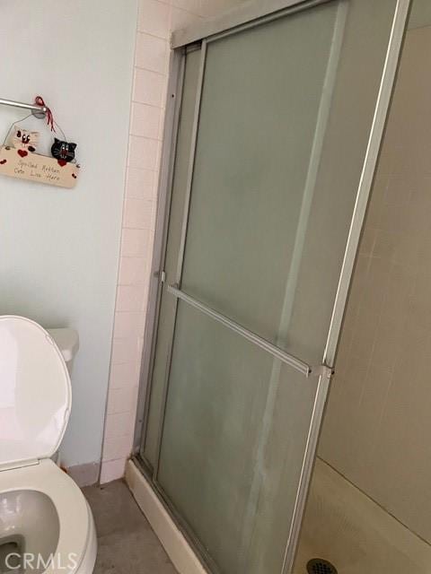 full bath with toilet and a shower stall