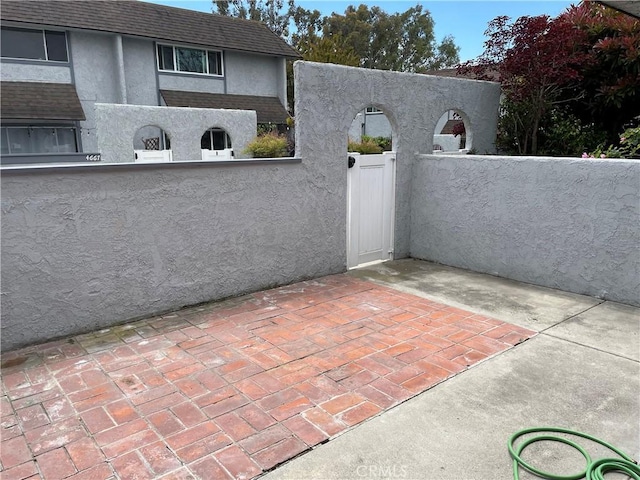 view of patio with a gate and fence