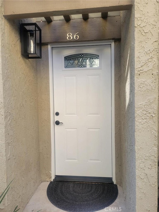 doorway to property featuring stucco siding