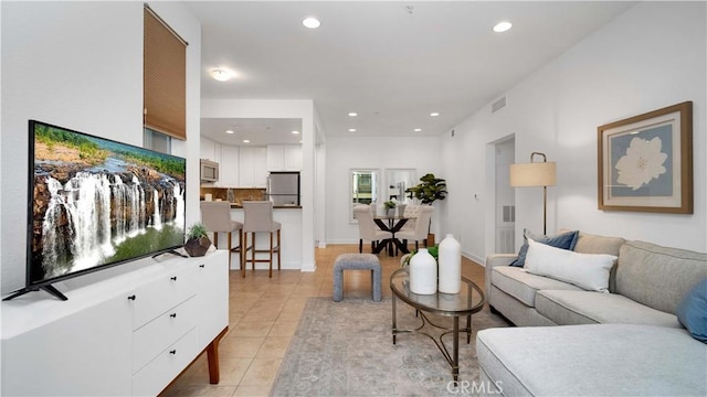 living area featuring recessed lighting, baseboards, visible vents, and light tile patterned floors