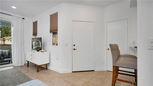 foyer entrance featuring light tile patterned floors, baseboards, and recessed lighting