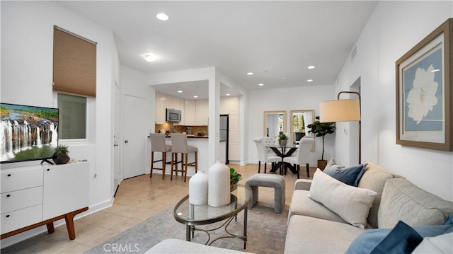 living room featuring light tile patterned flooring, recessed lighting, and visible vents