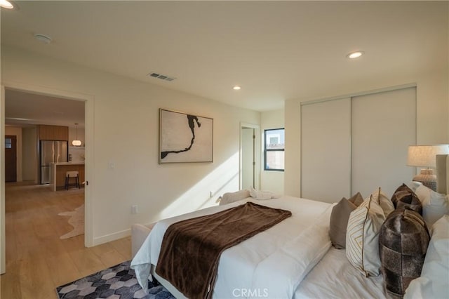23919 Friar St, Woodland Hills, CA 91367 - bedroom featuring stainless steel fridge, light wood-style flooring, a closet, recessed lighting, and baseboards
