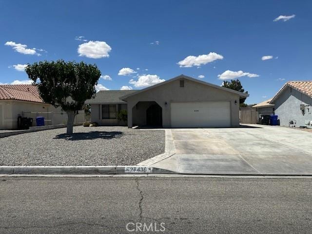 ranch-style house featuring an attached garage, stucco siding, and driveway