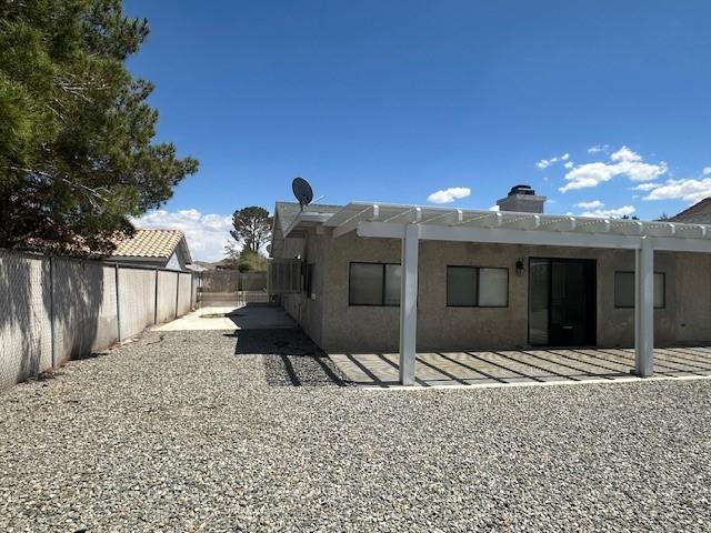 back of property featuring a fenced backyard, a patio area, stucco siding, and a chimney