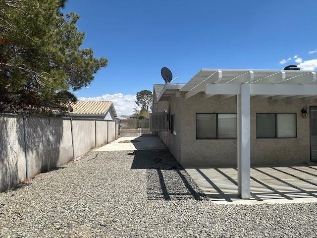 view of home's exterior featuring a patio, a fenced backyard, a pergola, and stucco siding
