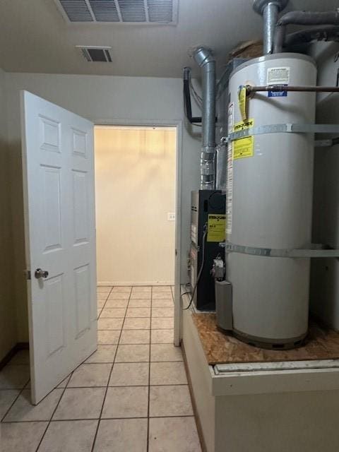 utility room featuring visible vents and water heater