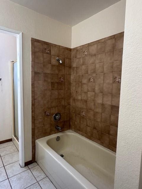 bathroom with a textured wall and tile patterned flooring