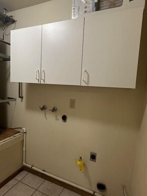 laundry room with light tile patterned flooring, baseboards, hookup for an electric dryer, cabinet space, and hookup for a gas dryer