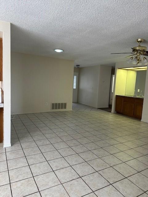 empty room featuring a ceiling fan, a textured ceiling, and visible vents