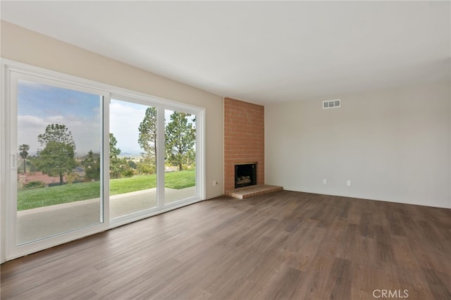 unfurnished living room featuring visible vents, wood finished floors, and a fireplace