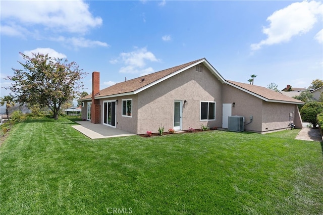 back of property featuring a lawn, stucco siding, a patio area, and central AC