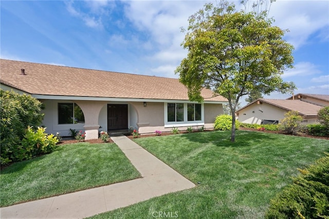 single story home with roof with shingles, stucco siding, and a front yard