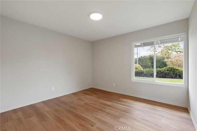 unfurnished room featuring baseboards and light wood-style flooring