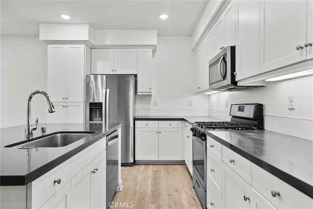 12814 Watt Ln Unit B, Sylmar, CA 91342 - kitchen with dark countertops, recessed lighting, white cabinetry, a sink, and appliances with stainless steel finishes