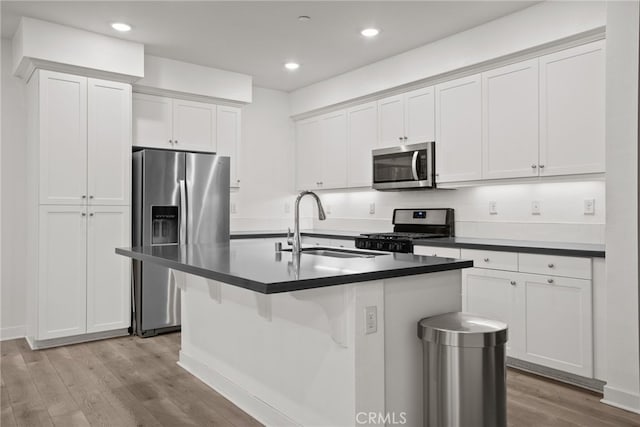 12814 Watt Ln Unit B, Sylmar, CA 91342 - kitchen with white cabinets, appliances with stainless steel finishes, a sink, light wood finished floors, and an island with sink