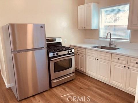 5214 Golden Ave, Riverside, CA 92505 - kitchen featuring light wood-type flooring, a sink, light countertops, white cabinets, and stainless steel appliances
