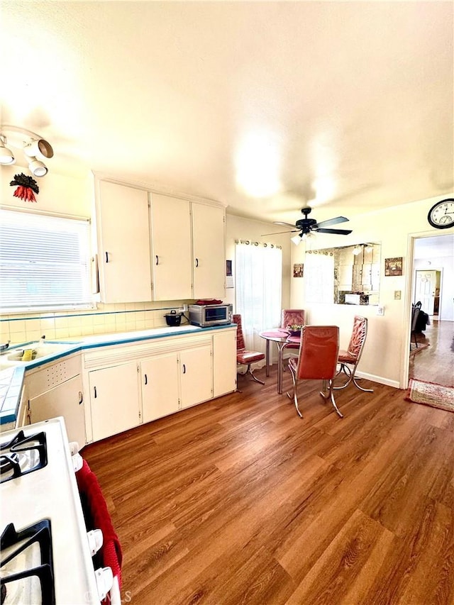 5214 Golden Ave, Riverside, CA 92505 - kitchen with ceiling fan, range with gas cooktop, a sink, light wood-style floors, and white cabinetry