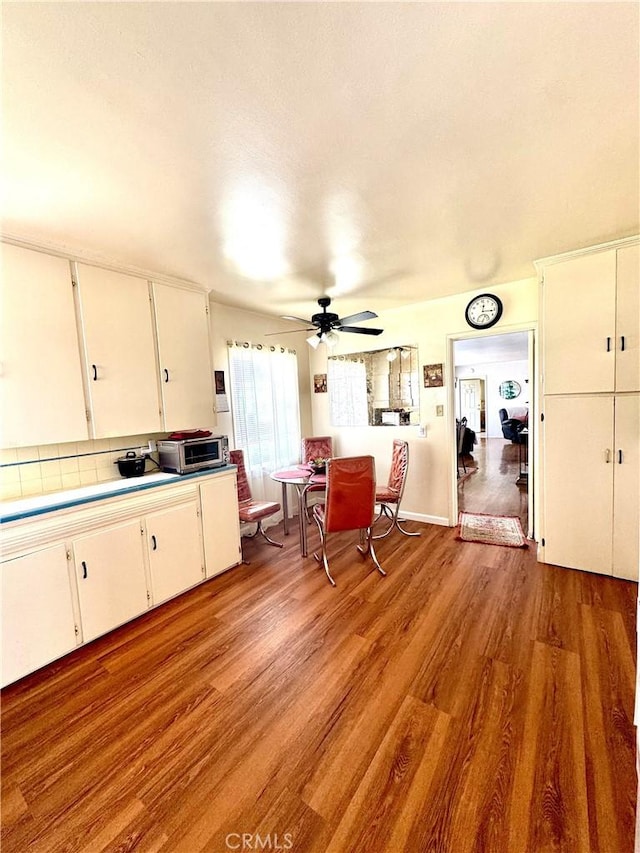 5214 Golden Ave, Riverside, CA 92505 - kitchen featuring light wood finished floors, light countertops, white cabinetry, a ceiling fan, and decorative backsplash