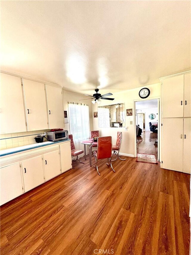 5214 Golden Ave, Riverside, CA 92505 - kitchen with ceiling fan, backsplash, light countertops, white cabinets, and light wood-style flooring