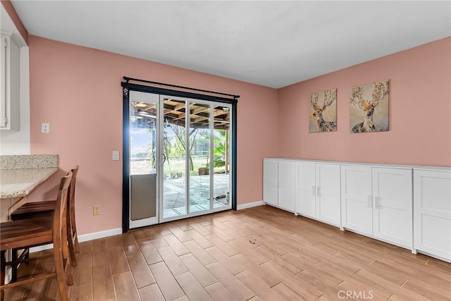 dining area featuring baseboards and light wood-style flooring