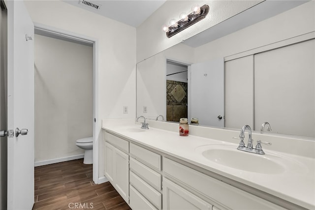 full bathroom featuring a sink, toilet, wood finished floors, and visible vents