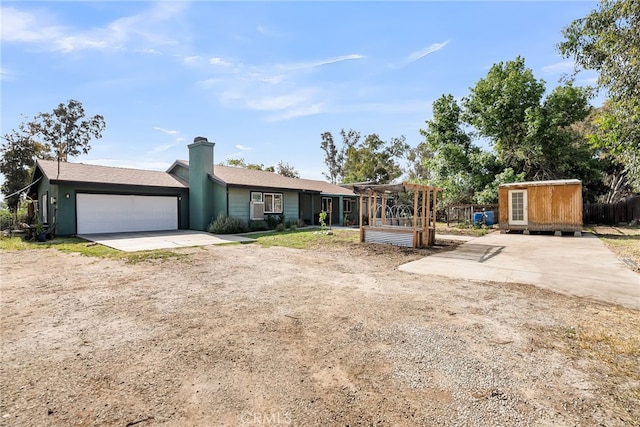 single story home featuring a garage, a pergola, and driveway