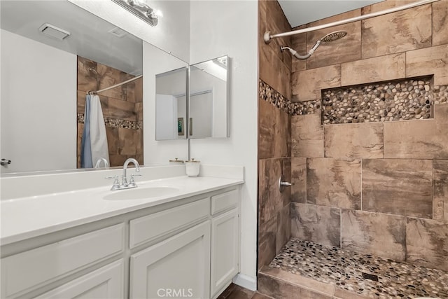 bathroom with vanity and tiled shower