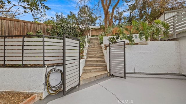 5092 Myrtle Ave, Riverside, CA 92506 - view of gate with stairway, a fenced backyard, and a patio