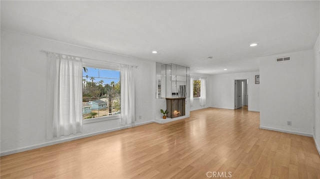 5092 Myrtle Ave, Riverside, CA 92506 - unfurnished living room with light wood finished floors, plenty of natural light, and visible vents