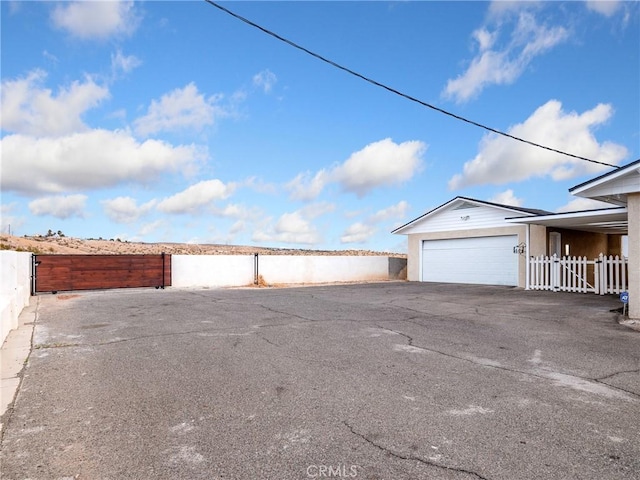 449 Highland Ave, Barstow, CA 92311 - garage featuring fence and aphalt driveway