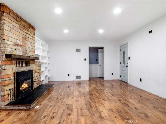 449 Highland Ave, Barstow, CA 92311 - unfurnished living room featuring recessed lighting, visible vents, wood finished floors, and a fireplace