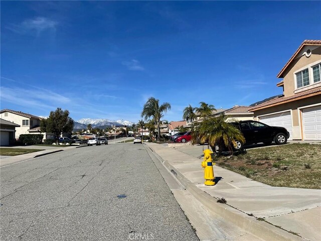 6483 N Walnut Ave, San Bernardino, CA 92407 - view of asphalt street featuring sidewalks, curbs, a residential view, and a mountain view