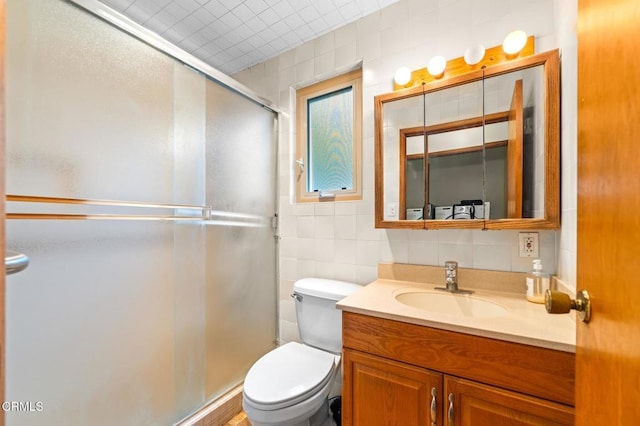 bathroom featuring vanity, tile walls, a stall shower, and toilet