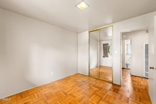 unfurnished bedroom with a closet and a heating unit