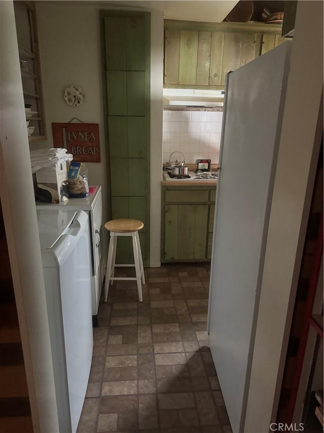 laundry room with laundry area, brick patterned floor, and washer and dryer