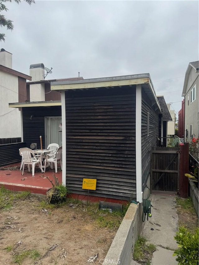 view of outdoor structure featuring a gate and fence