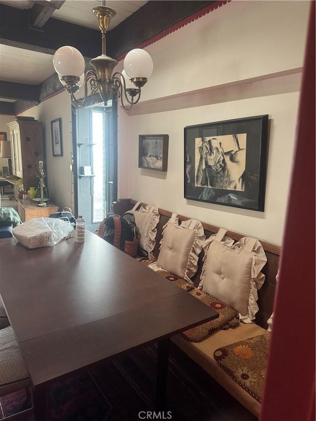 dining space with a chandelier and beamed ceiling