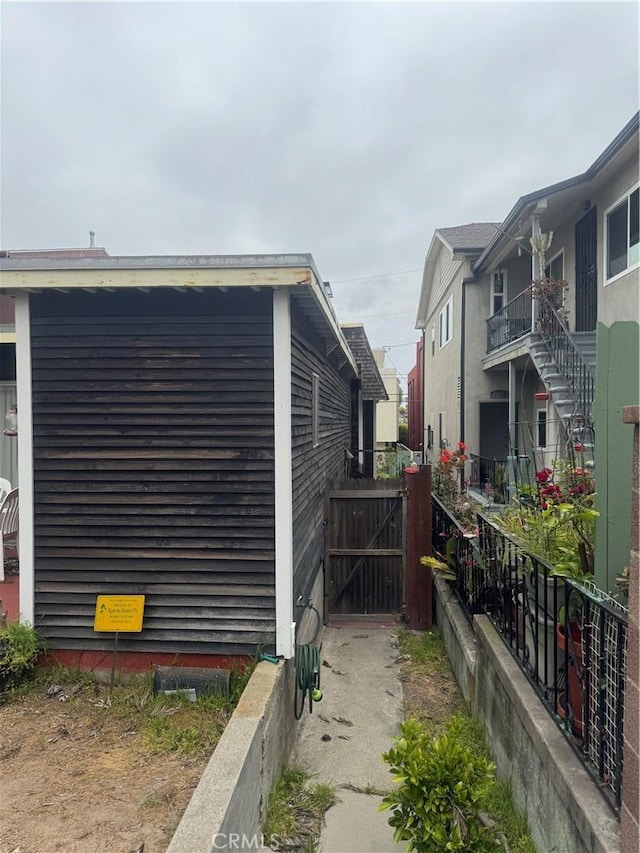 view of side of property featuring fence and a gate