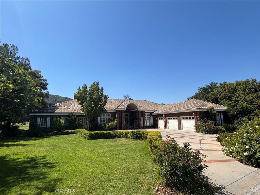 ranch-style home with an attached garage, concrete driveway, and a front yard