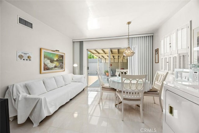 dining space featuring visible vents, washer / dryer, and light tile patterned floors