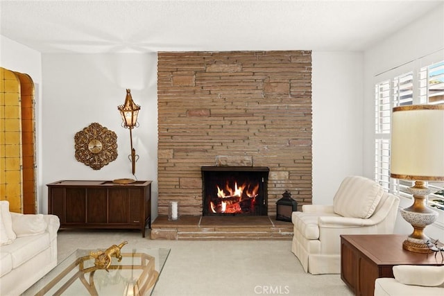 carpeted living area with a fireplace