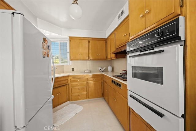 kitchen featuring light countertops, a warming drawer, decorative backsplash, and white appliances