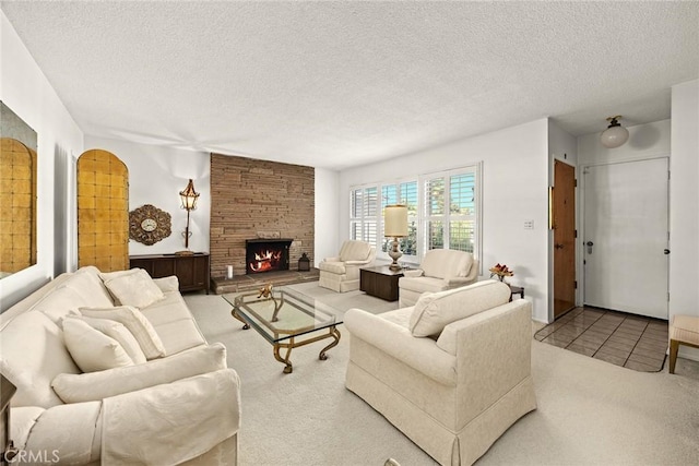 carpeted living area with a stone fireplace and a textured ceiling