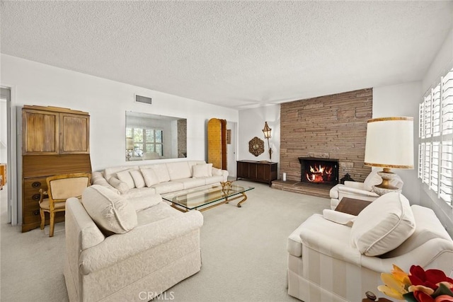 living area featuring a stone fireplace, visible vents, light carpet, and plenty of natural light