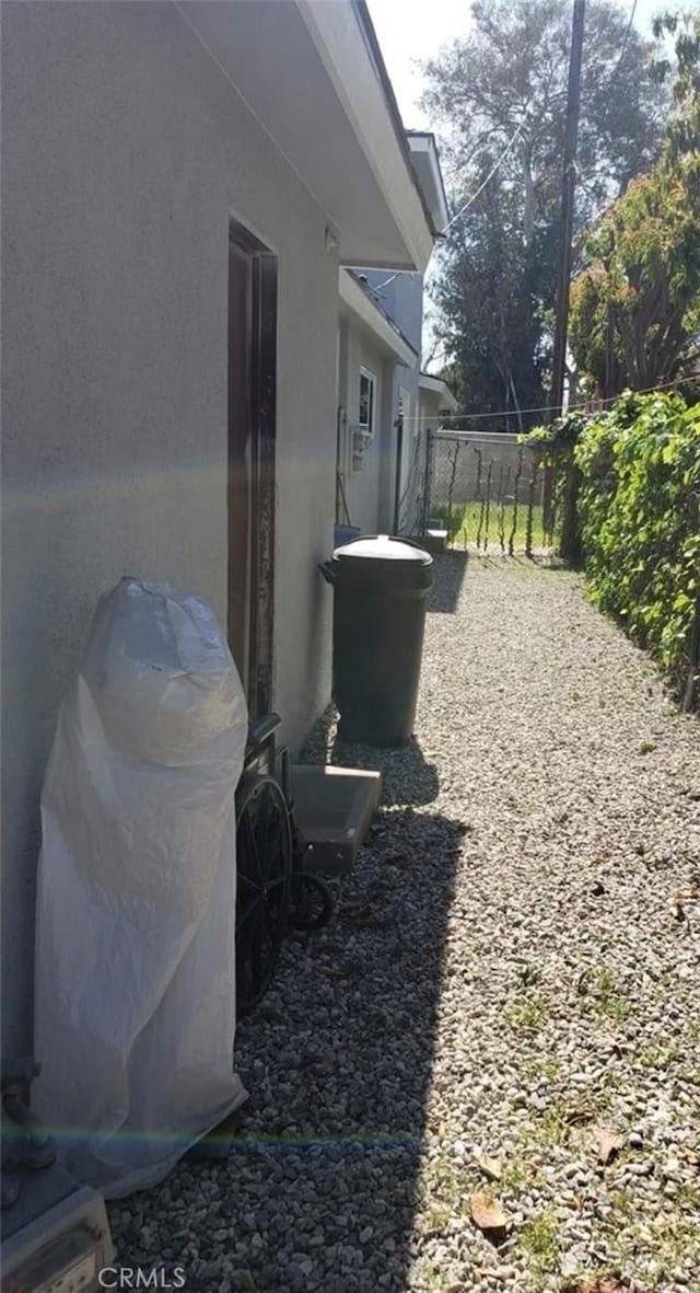 view of property exterior featuring stucco siding and fence