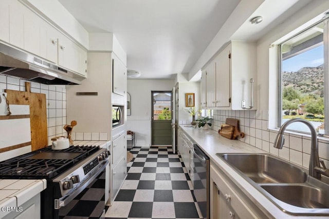 921 Topaz Ct, Ojai, CA 93023 - kitchen with white cabinets, a sink, dark floors, stainless steel appliances, and under cabinet range hood