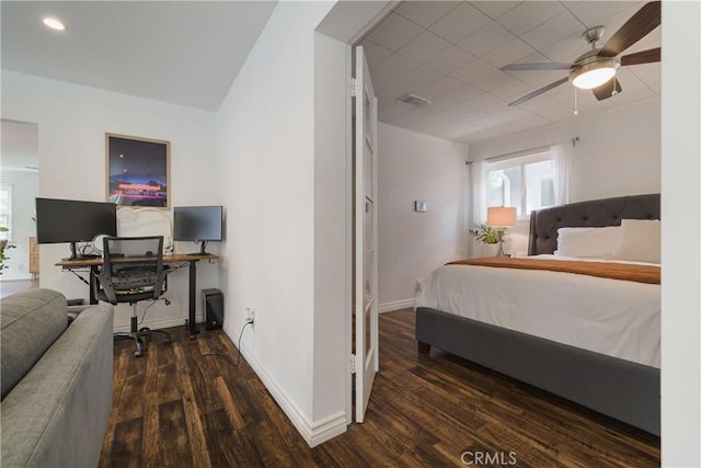 bedroom featuring visible vents, baseboards, wood finished floors, and multiple windows